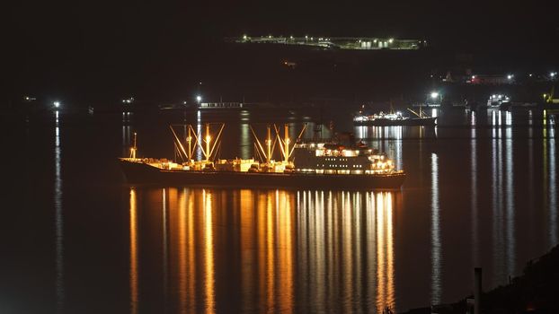 Night landscape with a fishing boat on the background of the sea. Vladivostok, Russia