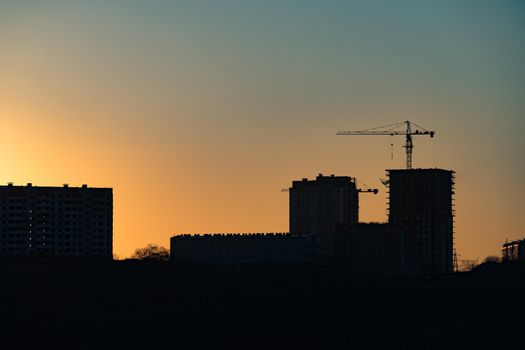urban landscape with silhouettes of high-rise buildings in the background light of the sunset.