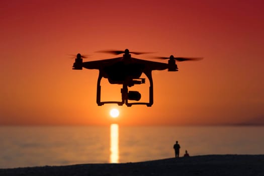 Silhouette of a quadrocopter on sunset background