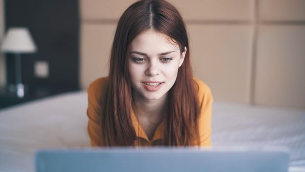 woman with laptop lies in bed sleeping room rest communication. High quality photo