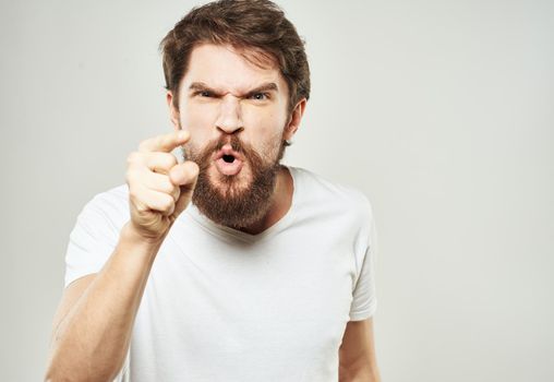 Aggressive man gestures with his hands on a light background stress emotions irritability. High quality photo