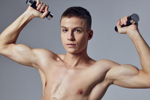 handsome man with a pumped-up body dumbbells in his hands workout muscles. High quality photo