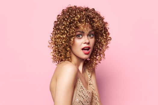 Female Curly hair surprised look pink background portrait bright makeup close up
