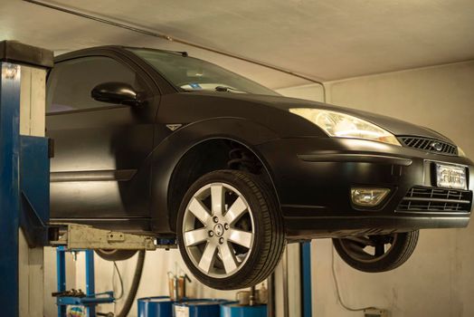 MILAN, ITALY 17 FEBRUARY 2021: Automobile on overhead crane in the workshop for maintenance