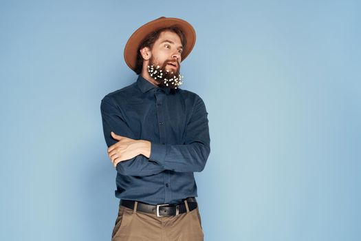 Man in flowers hat in beard emotions ecology style blue background. High quality photo