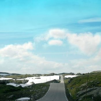 High mountain road with snowy spots