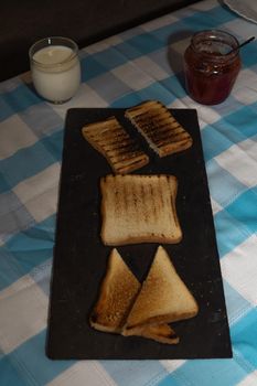 Toasted bread board with jams and a pretty blue and white tablecloth