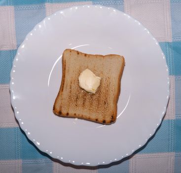 Toasted bread with butter on a white plate
