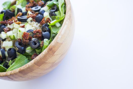 Quinoa, lettuce, lambs lettuce, black olives and cucumber salad. No people