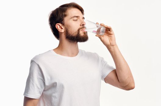 handsome guy with a glass of water on a white background t-shirt cropped view Model. High quality photo