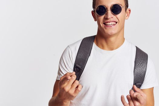 Cheerful young guy in sunglasses backpack lifestyle fashion clothes. High quality photo