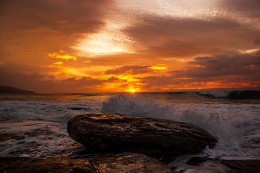 waves crushing a rock during sunrise. Sea sunrise at the great Ocean Road, Victoria