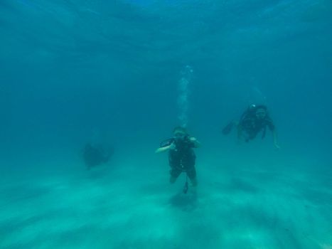 GREAT BARRIER REEF, AUSTRALIA - OCT 13, 2015: 3 Scuba diving tourist are swimming at the great barrier reef