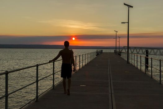 young man walking on a yetty with beautiful sunset