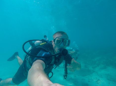 GREAT BARRIER REEF, AUSTRALIA - OCT 13, 2015: Scuba diving man tourist make a thumbs up for showing everything is okay
