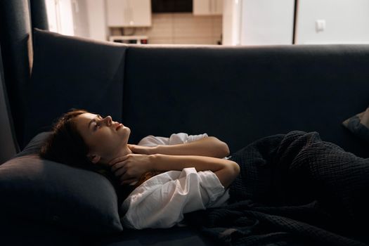 woman in white t-shirt resting lying on sofa indoors cropped view. High quality photo
