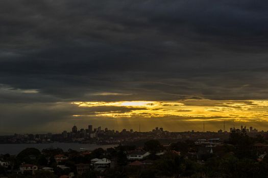Sydney Panorama taken from a unique position at sunset, sunrays shining on the city, New South Wales, Australia