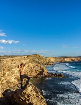 jung man standing on cliffs near port lincon at sunset, South Australia, australia
