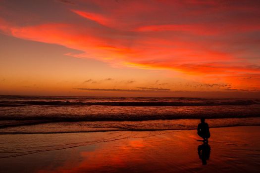 Young man sitting outdoors watching the sunset. Thinking and relaxing concept.