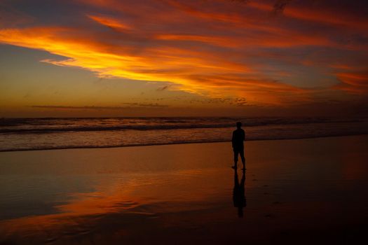 Young man sitting outdoors watching the sunset. Thinking and relaxing concept.