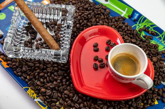 composition of coffee beans with heart shaped cup and saucer with ashtray and cigar