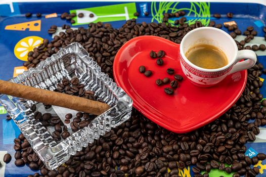 composition of coffee beans with heart shaped cup and saucer with ashtray and cigar