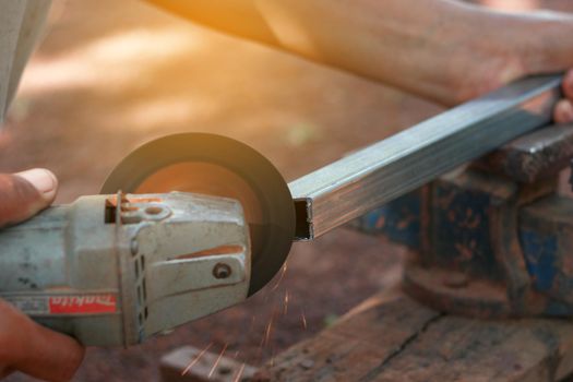 Technician cutting steel with tool in the workplace.