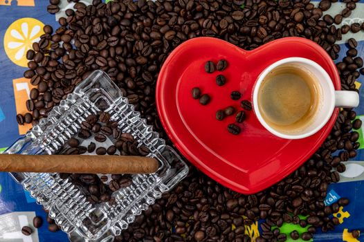 composition of coffee beans with heart shaped cup and saucer with ashtray and cigar