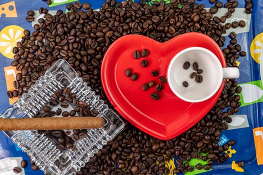 composition of coffee beans with heart shaped cup and saucer with ashtray and cigar