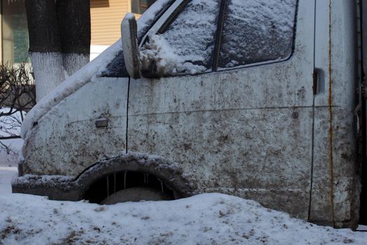 small dirty semitruck freezed in the snowdrift in roadside at winter daylight