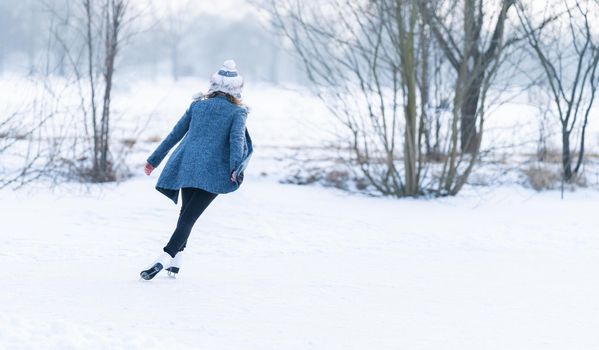 ice skating on the ice of a frozen lake young attractive woman.