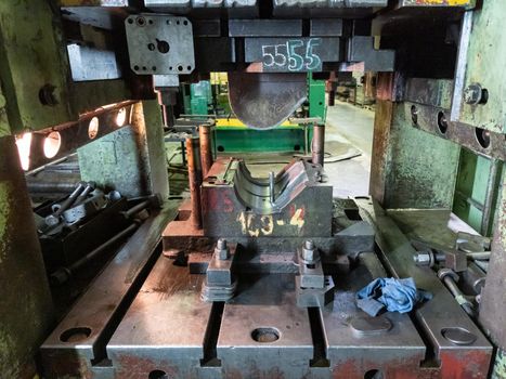 dirty used low tech stamping press with sheet metal die tooling.
