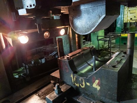 dirty used low tech stamping press with sheet metal die tooling.