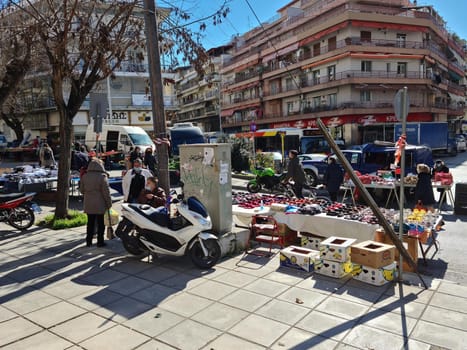 Crowd wearing covid-19 face protection, at bazaar called Laiki in Greek, with street vendors.