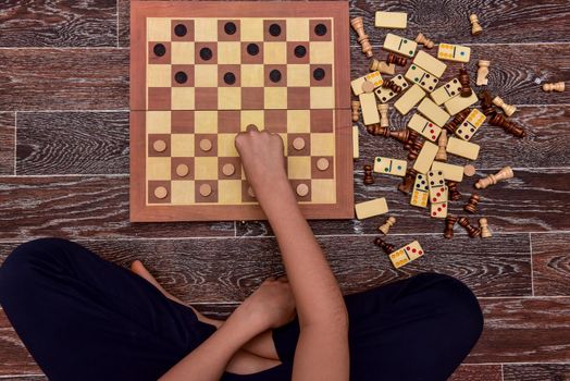 boy plays checkers, chess, dominoes and backgammon. set of board games.