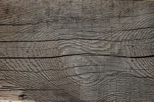 Texture of black and dark brown old wood. An old Board with knots. Wide texture of the old Board close-up. The texture of the barn. Wooden texture may used as background.