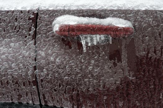 Frozen car door closeup, icicles, ice crystals, jammed lock.