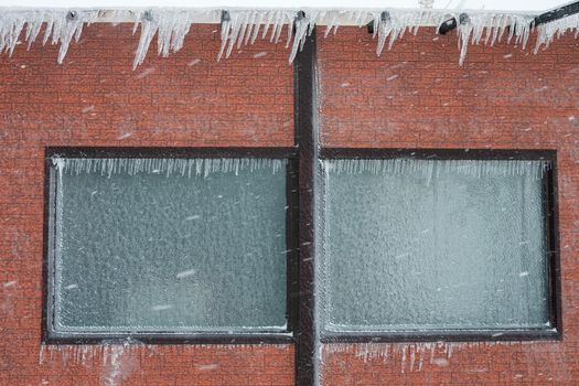 walls and windows of the building are covered with ice and icicles.