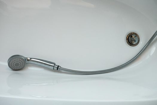 Wet shower head lying in the shower stall. Close up, copy space.