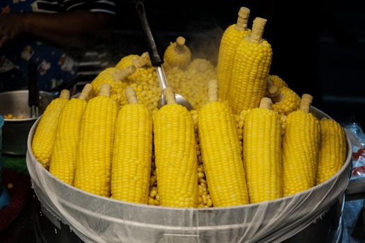 Boiled corn in a large vat at a street food market.