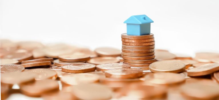 Miniature home model on stack coins building money house loan property value time rent or buy real estate. Property banner home money coins tower profit real estate investment or household income rate