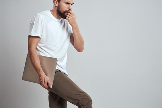man in t-shirt laptop in hands technology communication studio. High quality photo