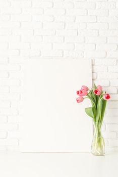 Mock up design. Mock up with Frame and pink Tulips on white brick wall background