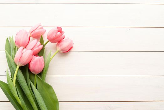 Spring, flowers concept. Pink tulips over white wooden table background with copy space