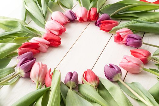 Love concept. Heart shape made of spring tulip flowers, copy space inside.