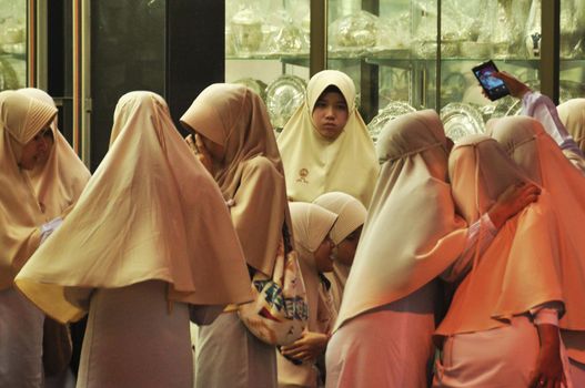 NAKHON SI THAMMARAT, THAILAND - 14 JULY 2016. Group of Muslim women with heads covered standing indoors spending time together. Group of religious women in public