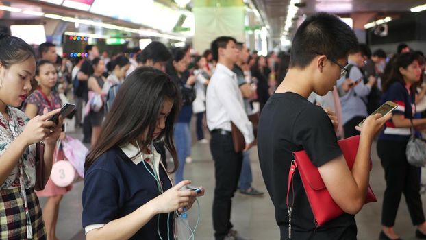 BANGKOK, THAILAND - 18 DECEMBER, 2018: Passenger at BTS Skytrain station in Bangkok Thailand, everybody looking down at smartphone while waiting for the BTS skytrain.