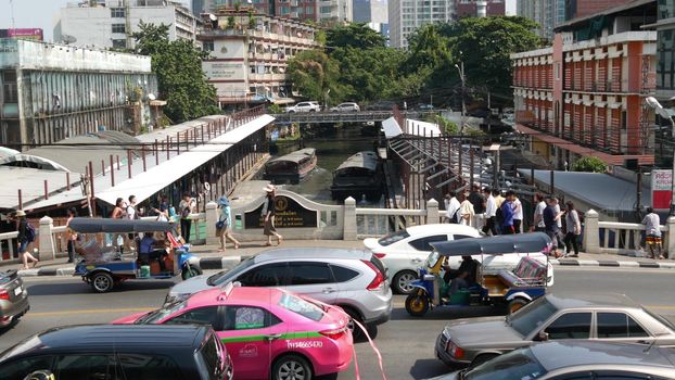 BANGKOK, THAILAND - 18 DECEMBER, 2018 Pratunam pier, express boat public transport stop in center of city. Saen Saep canal. Busy traffic on Ratchadamri road