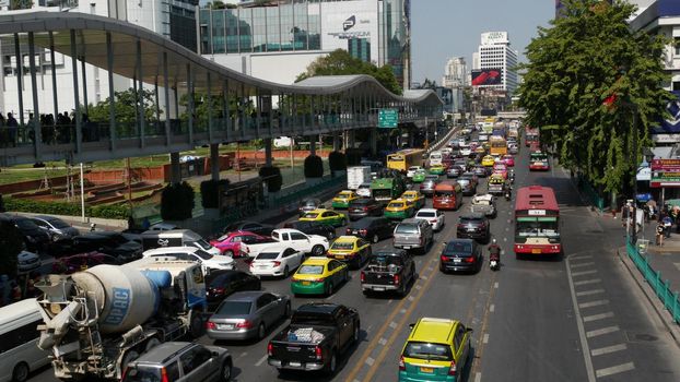 BANGKOK, THAILAND - 18 DECEMBER, 2018: Cars on busy city street. Many modern cars and buses riding on busy street on sunny day. traffic congestion, overpopulation, environmental problems in cities