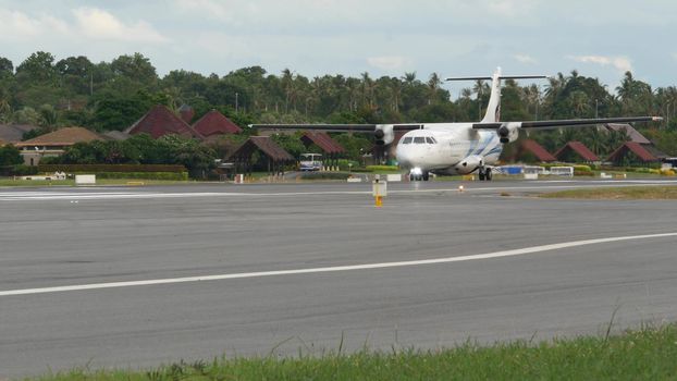 KOH SAMUI ISLAND, THAILAND - 23 JUNE 2019 White airplanes flying and landing on airport runway of Bangkok Airways company in exotic touristic resort. Vacation, travel and transportation concept.